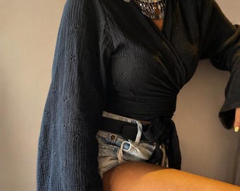 Top corto negro de algodón orgánico con ojales – Blusa cruzada con lazo frontal y mangas acampanadas
