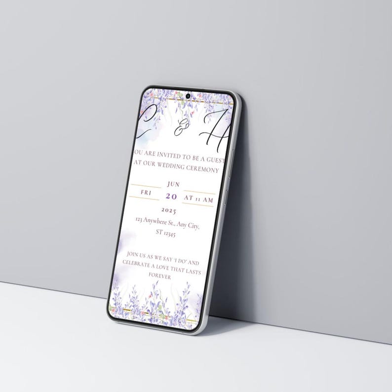 K&ouml;nnte beinhalten: Ein Smartphone zeigt eine Hochzeitseinladung mit lila und wei&szlig;en floralen Akzenten. Die Einladung enth&auml;lt Datum, Uhrzeit und Ort der Zeremonie sowie den Text "Sie sind eingeladen, Gast unserer Hochzeitszeremonie zu sein."