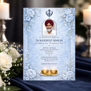 May include: A memorial card with a portrait of Sukhdeep Singh, framed by light blue floral designs. The card includes dates, times, and locations for memorial services. Two lit candles and a floral arrangement are in the background.