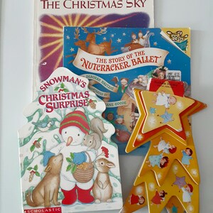 May include: A collection of children's books about Christmas, including "The Christmas Sky", "The Story of the Nutcracker Ballet", and "Snowman's Christmas Surprise".