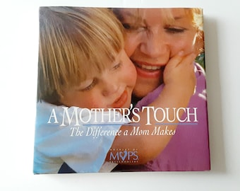 May include: A square book titled A Mother's Touch: The Difference a Mom Makes, featuring a photograph of a child embracing a woman. The cover includes the MOPS logo and text, with the child wearing a white shirt and the woman in a purple top.