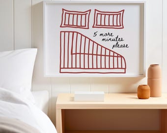 Könnte beinhalten: Ein gerahmter Druck mit minimalistischem Design, der eine Bettillustration in Dunkelrot auf weißem Hintergrund zeigt. Der Text "5 more minutes please" ist handschriftlich geschrieben. Das Kunstwerk wird über einem Nachttisch aus Holz ausgestellt.