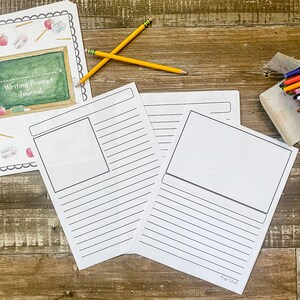 May include: A writing prompt journal with lined pages and a blank space for illustrations. Two yellow pencils and a journal cover with the text "Writing Prompt Journal" are also visible. The journal is designed for creative writing and journaling.