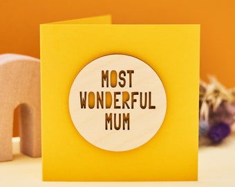 May include: Yellow card with a wooden circle cutout that says "Most Wonderful Mum" in a simple font.