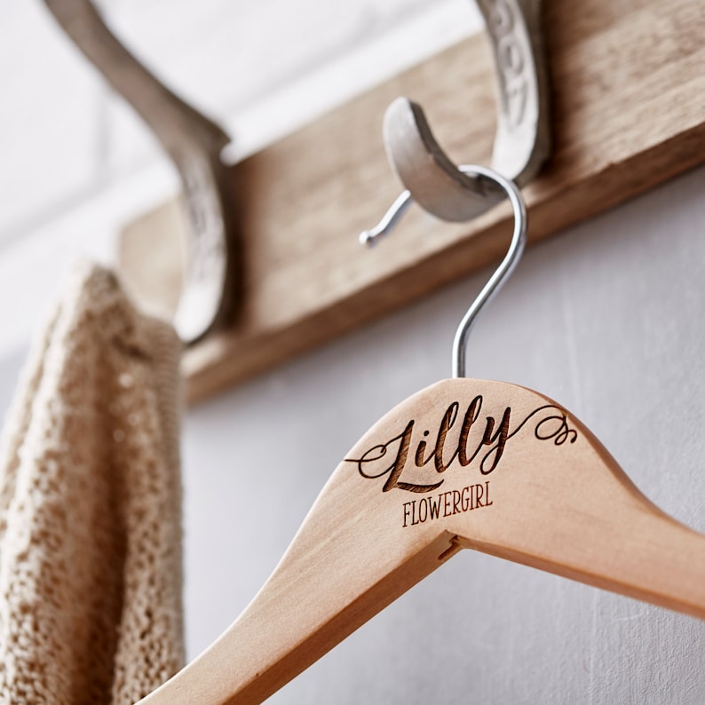 May include: Wooden hanger with the name "Lilly" and the text "Flowergirl" engraved on it.