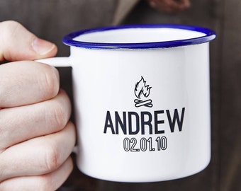 Könnte beinhalten: Weiße Email Tasse mit blauem Rand und einem schwarzen Lagerfeuer-Design. Die Tasse sagt "ANDREW 02.01.10"