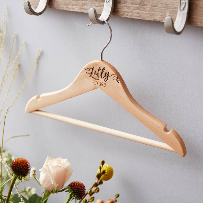 May include: A wooden hanger with the name "Lilly" and the words "Flowergirl" engraved on it.