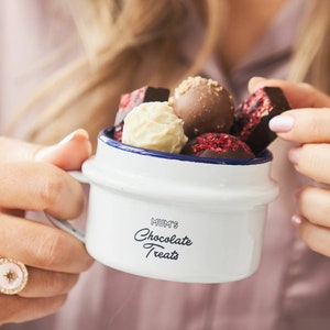 Pode incluir: Caneca de esmalte branco com borda azul e o texto "Mum's Chocolate Treats" impresso no lado. A caneca está cheia de trufas de chocolate sortidas.