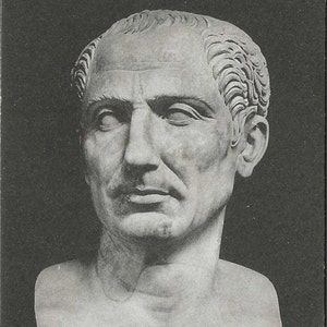 May include: A black and white bust sculpture of a man with short, wavy hair. The sculpture is made of marble and depicts a Roman emperor.