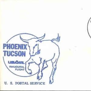 May include: A blue and white stamp featuring a stylized bull and text. The text reads "PHOENIX TUCSON" and "USAIR INAUGURAL FLIGHT" within a circular border. The words "U. S. POSTAL SERVICE" are at the bottom.