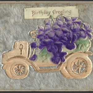 Ancienne carte postale d'anniversaire fantaisie ancienne voiture remplie de violettes - Bas-relief des années 1910 avec fond texturé velu
