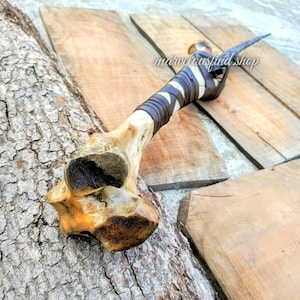 May include: A handmade bone-handled knife with a dark blade. The handle is wrapped in brown leather and white material. The text "marvelousfind shop" is visible on the wooden surface.