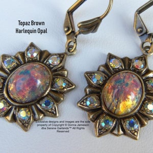 Pode incluir: Um par de brincos dourados com um caboch&atilde;o de opala harlequim marrom top&aacute;zio engastado em um design de raios de sol com detalhes em cristal transparente.  "Topaz Brown Harlequin Opal" e "Exclusive designs and images are the sole property of Copyright &copy; Donna Jameson dba Serene Garlands&trade; All Rights Reserved" est&atilde;o impressos na imagem.