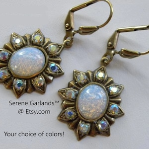 Pode incluir: Um par de brincos dourados com uma pedra de opala branca cercada por strass transparentes em um design de raios de sol. Os brincos t&ecirc;m um fecho de alavanca. Serene GarlandsTM @Etsy.com Sua escolha de cores!