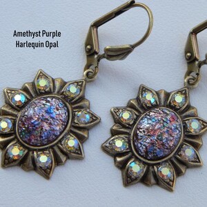 Pode incluir: Um par de brincos de bronze com uma pedra de opala p&uacute;rpura e iridescente engastada em um design de sol com strass transparentes.