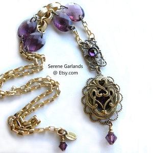 May include: A gold chain necklace with a purple glass pendant. The pendant is a filigree design with a purple glass stone in the center. The necklace also has purple glass beads.