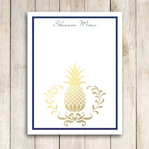 May include: White notepad with a blue border and the name "Shannon Mims" printed at the top. A gold pineapple design is centred on the notepad.
