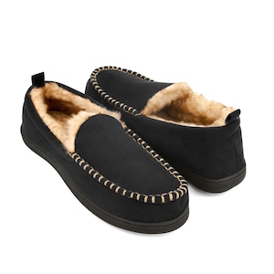 May include: Black suede slippers with a faux fur lining and a brown stitch detail around the edge.