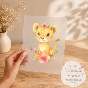 Könnte beinhalten: Ein durchscheinendes Blatt mit einer Aquarellillustration eines hellbraunen Löwenbabys mit einer rosa Blume auf dem Kopf, umgeben von bunten Blumenakzenten und Blattwerk. Das Motiv ist auf dem klaren, halbtransparenten Material zentriert.