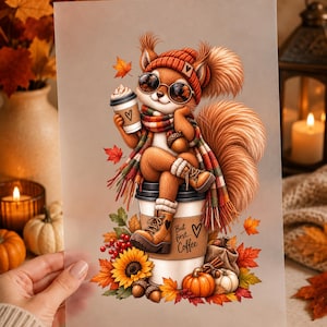 May include: A print featuring a squirrel wearing a red knit hat, sunglasses, and a plaid scarf, holding a coffee cup. The squirrel sits on a large coffee cup labelled "But first... Coffee" with a heart. The base includes pumpkins, sunflowers, and leaves.