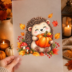 Könnte beinhalten: Ein durchscheinendes Blatt mit einer farbenfrohen Illustration eines lächelnden Igels, der einen orangefarbenen Kürbis hält, umgeben von roten und gelben Herbstblättern, kleinen roten Beeren, zwei rot-weiß gepunkteten Pilzen und braunen Eicheln.