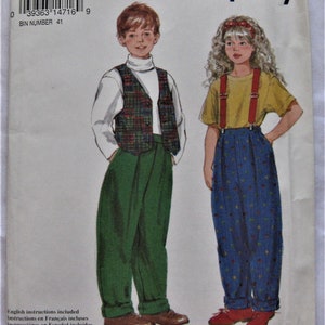 May include: A sewing pattern for children's clothing. The pattern includes instructions in English, French, and Spanish. The pattern is for a boy wearing a plaid vest and green pants and a girl wearing a yellow shirt with red suspenders and blue polka dot pants.