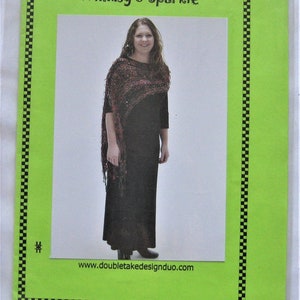 May include: A crochet pattern for a shawl called "Whimsy & Sparkle" featuring a woman wearing a black dress and a shawl. The pattern is available on the website doubletakedesign duo.com.