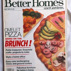 May include: A magazine cover for Better Homes and Gardens, featuring a pizza with various toppings, including avocado, ham, sausage, and shrimp. The cover text reads "Omelet Pizza Bring on the Brunch!" and includes a list of articles such as "Petite treasures: Exquisite crafts projects to make", "Style a home office", "Easy-care landscaping: Vines and ground covers", "Fabulous furniture for today's home", and "Solutions for problem kitchens".