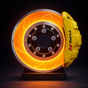 Op de afbeelding: Gedetailleerde afbeelding van een remschijf en remklauw van een auto. De schijf is oranje met geboorde gaten en een zilveren rand. De gele remklauw is gemarkeerd met "TYPE R". De montage is gemonteerd op een zwarte basis tegen een donkere achtergrond.