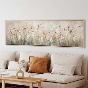 Peut inclure: Une œuvre d'art murale rectangulaire panoramique représentant une scène de prairie florale impressionniste avec des tons doux de rose, de blanc et de vert sourd. Le tableau est encadré de bois clair et présente des coups de pinceau texturés.