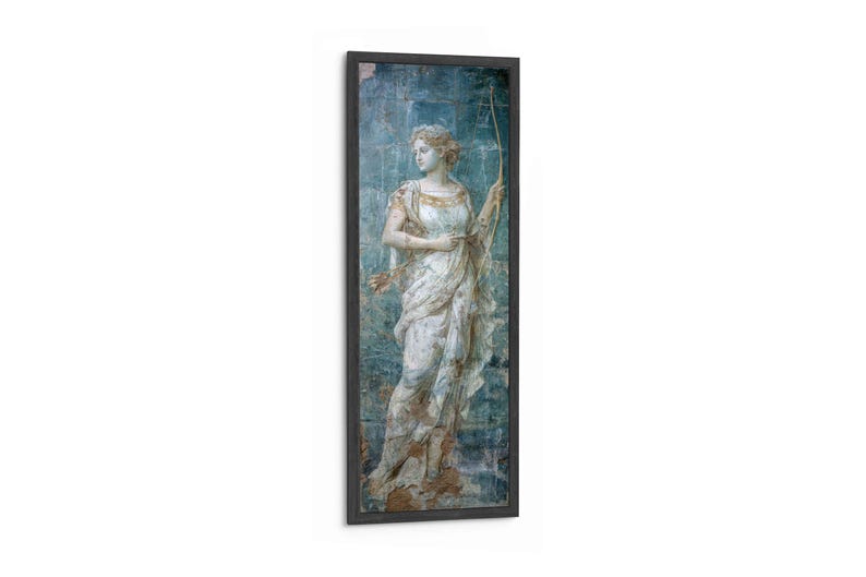 May include: A vertical framed wall art piece featuring a classical figure in a white draped garment holding a long bow. The figure stands against a textured blue background with weathered details. The frame is dark and rectangular in shape.