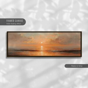 May include: A panoramic framed canvas print featuring an oil painting of a sunset over the ocean. The artwork displays warm orange and golden hues across the sky and water, with a dark brown frame. Text on the image reads FRAMED CANVAS.