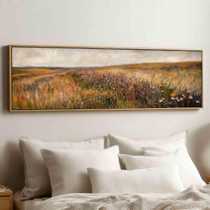Könnte beinhalten: Ein panoramisches Landschaftsgemälde in einem dünnen goldenen Rahmen, das ein weites Feld mit goldenen Gräsern und Wildblumen unter einem bewölkten Himmel zeigt. Das Kunstwerk weist strukturierte Pinselstriche in Ocker, Grün, Lila und Weiß auf.