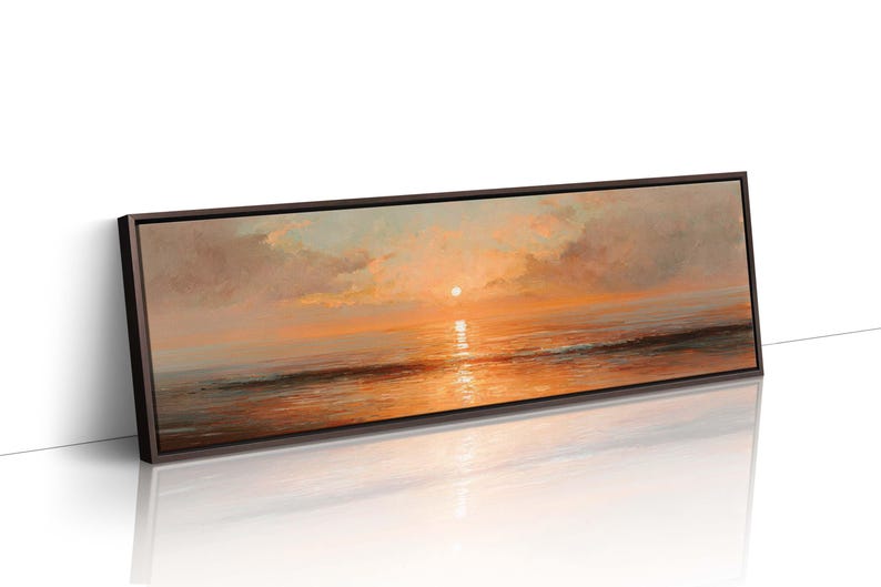 May include: A panoramic landscape painting in a dark brown frame depicting a sunset over the ocean. The scene features a bright sun low on the horizon, casting warm orange and golden light across the clouds and the calm, reflective water surface.