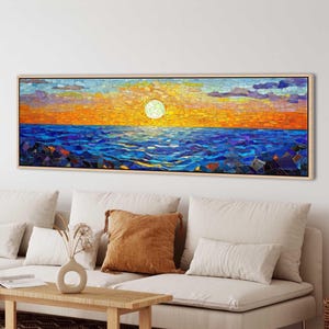 Könnte beinhalten: Ein Mosaik-Kunstwerk zeigt einen Sonnenuntergang über dem Meer. Die Sonne ist ein leuchtend gelber Kreis, und der Himmel geht von Orange in Blau über. Das Meer ist tiefblau mit mosaikartigen Details. Das Kunstwerk ist in hellem Holz gerahmt.