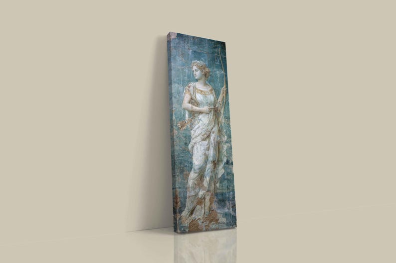 May include: A tall, rectangular canvas print featuring a classical statue of a figure in a draped white gown holding a bow. The artwork displays a weathered, blue-toned background with textured, distressed details and subtle gold accents on the clothing.