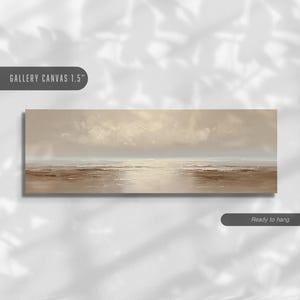 May include: A rectangular canvas print depicting a serene seascape. The artwork features a muted color palette of beige, brown, and white, with a cloudy sky and calm water. The text "GALLERY CANVAS 1.5" and "Ready to hang" are visible.