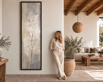 Puede incluir: Una pieza de arte mural enmarcada, alta y rectangular, que presenta una ilustración botánica vertical de una planta delicada de tallo fino con pequeñas flores blancas sobre un fondo abstracto texturizado de tonos beige, gris y blanco.