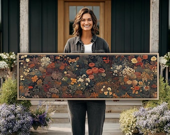Puede incluir: Una pieza de arte mural rectangular que presenta un estampado botánico denso en tonos oscuros con una variedad de flores en tonos naranja, rojo, amarillo y verde apagado. La obra está enmarcada en un marco de madera clara con borde simple.