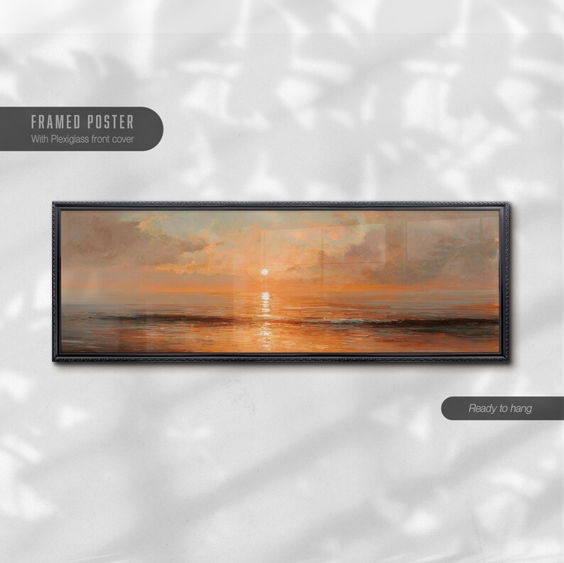 May include: A panoramic framed poster featuring a sunset over the ocean with orange and gold hues reflecting on the water. The artwork is enclosed in a thin black frame with a plexiglass front cover. The text reads Framed Poster and Ready to hang.