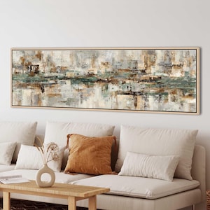 May include: Abstract landscape painting in a rectangular wooden frame. The artwork features a blend of neutral colours, including beige, grey, and brown, with accents of teal. The painting's style is modern and evokes a sense of nature.
