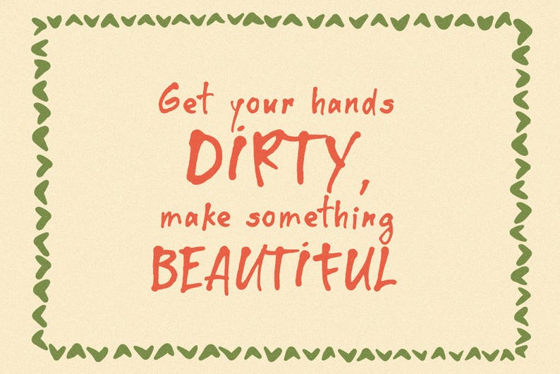 Op de afbeelding: Een cr&egrave;mekleurige rechthoekige kaart met een groene hartvormige rand. De tekst in het midden luidt "Get your hands DIRTY, make something BEAUTIFUL" in rode, handgeschreven letters.