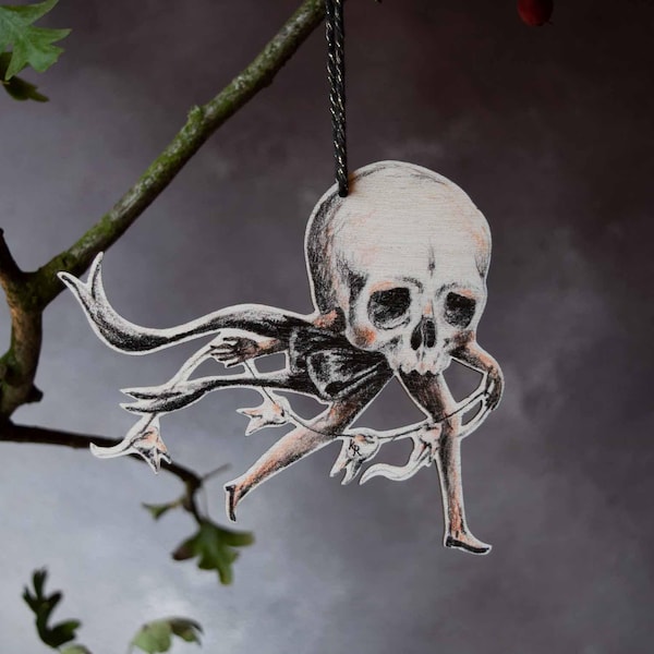 Wooden skull with teeth hanging ornament, illustrated by Kayleigh Radcliffe. Made in Britain
