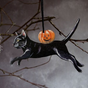 Black cat with a pumpkin, Halloween hanging ornament. Vintage Halloween style decor made from wood