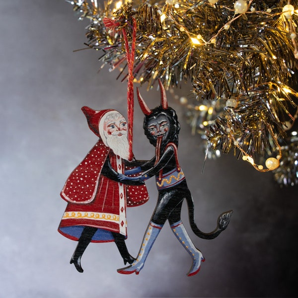 Wooden hanging Christmas ornament featuring Saint Nick dancing with the Christmas Krampus