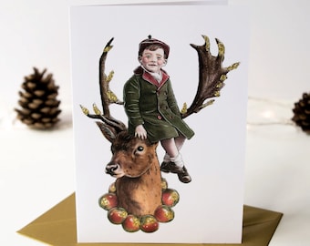 Victorian Edwardian boy sat on a reindeer stag. Christmas card. Embellished with gold glitter. Card for a loved one. Card for a man.
