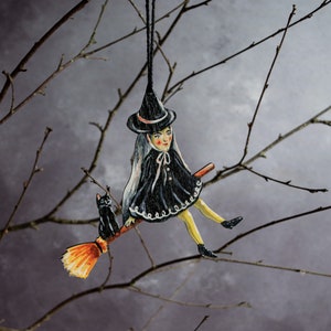 Wooden witch hanging ornament. Witch on a broomstick with her black cat Halloween decoration