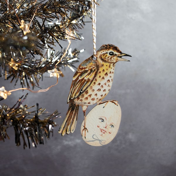 Wooden hanging ornament of a thrush bird and egg. Quirky holiday decoration, for all year round display. Made in the UK from laser cut wood