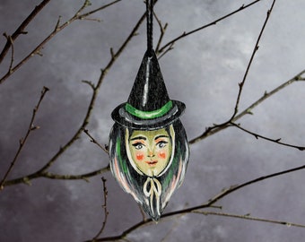 Vintage style witch head hanging ornament made from wood. Retro Halloween decor
