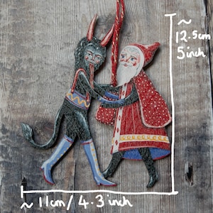 Wooden hanging Christmas ornament featuring Saint Nick dancing with the Christmas Krampus image 9